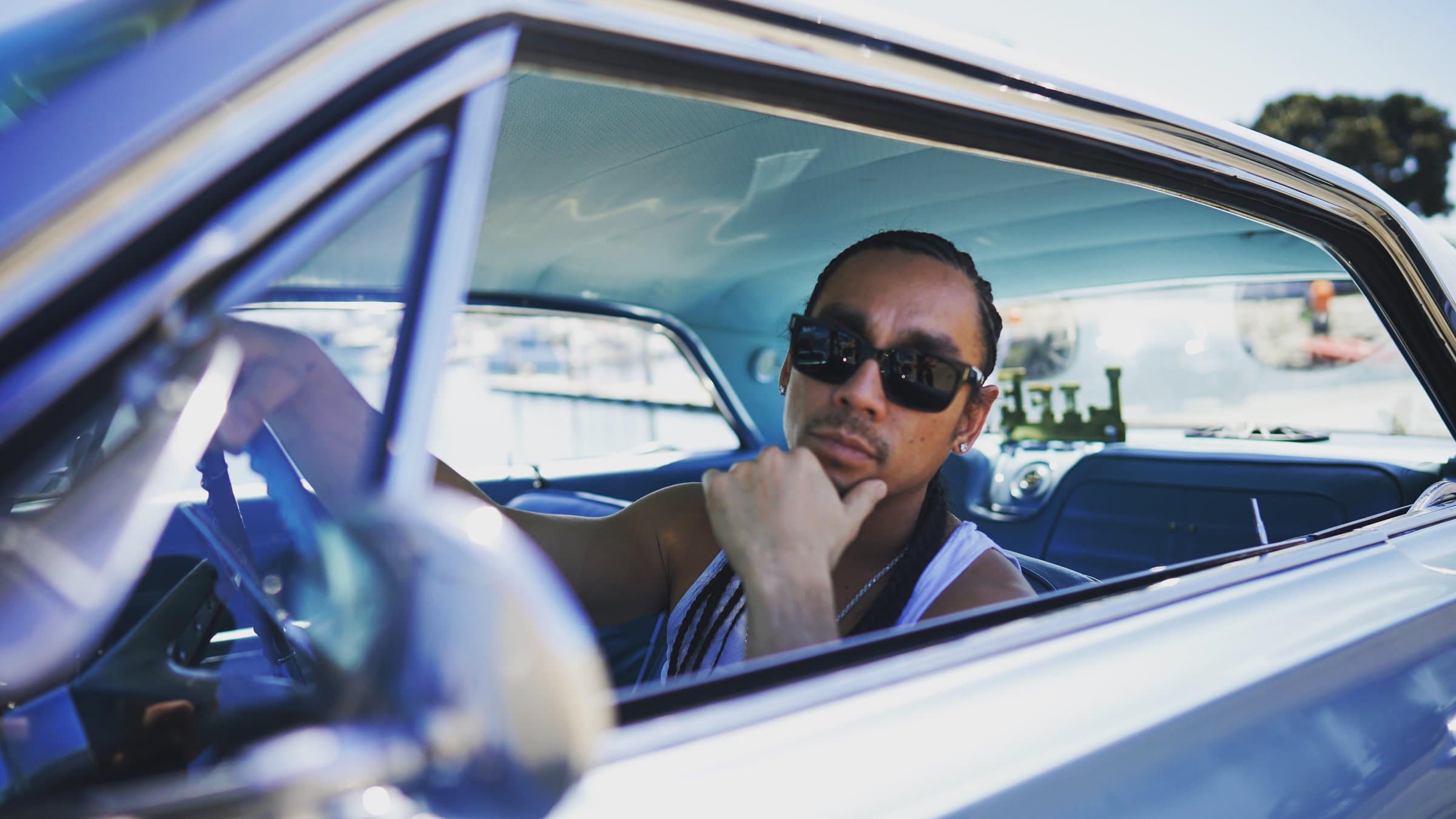 Kekoa behind the wheel of a vintage car